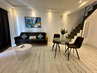 a living room with a couch and a table at 1-bedroom duplex 100m by the sea in Limassol