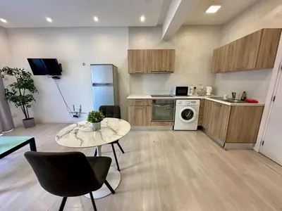 a kitchen with a table and a stove top oven at 1-bedroom duplex 100m by the sea in Limassol