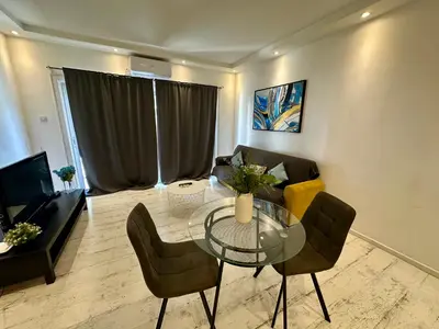 a living room with a glass table and a couch at 1-bedroom duplex 100m by the sea in Limassol
