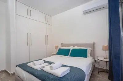 a bedroom with a large bed with towels on it at White Arches Apt #2 by TrulyCyprus in Limassol