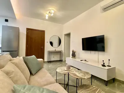 a living room with a couch and a flat screen tv at White Arches Apt #2 by TrulyCyprus in Limassol