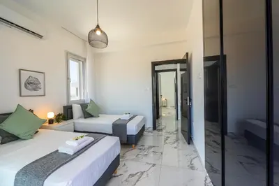 a bedroom with two beds and a living room at Protaras Sol e Mar Villa 3 in Protaras