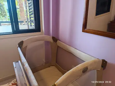 a baby crib in a room with a window at Palm garden paradise in Pervolia