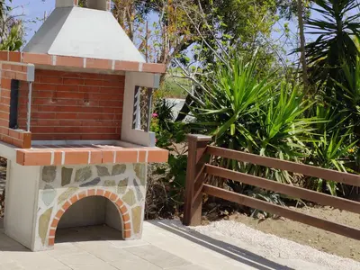 a brick oven next to a wooden fence at Palm garden paradise in Pervolia