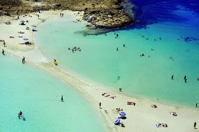 a group of people in the water at a beach at Palm garden paradise in Pervolia