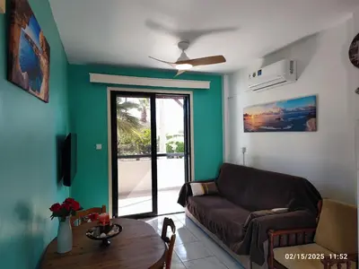 a living room with a couch and a table at Palm garden paradise in Pervolia