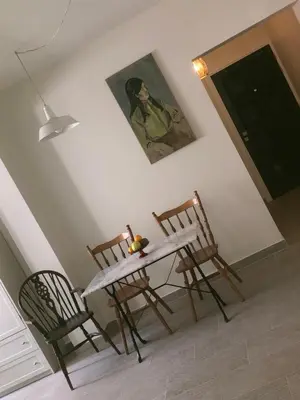 a table and two chairs in a room with a painting at T&L Apartments Germasogia in Limassol