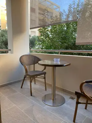 a table and two chairs sitting next to a window at T&L Apartments Germasogia in Limassol