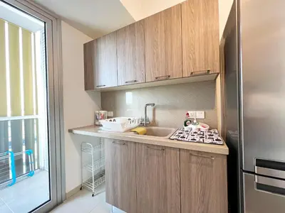 a kitchen with wooden cabinets and a stainless steel refrigerator at Albert's apartment St. Lazarus 401 in Larnaka