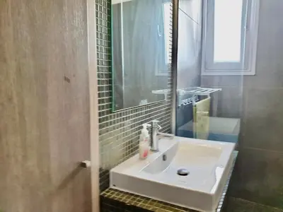 a bathroom with a white sink and a mirror at 2-bedroom appartment in center in Nicosia