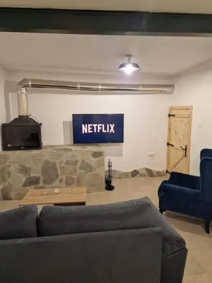 a living room with a couch and a sign that reads netflix at Aprosmeno Jacuzzi House 3 With Private Pool in Agros