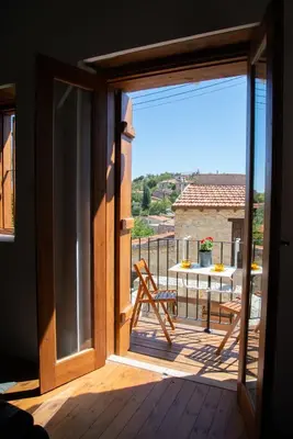 a sliding glass door leading to a balcony with a table at Cleo's Inn in Lofou