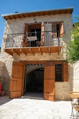 a building with a balcony and a patio at Cleo's Inn in Lofou