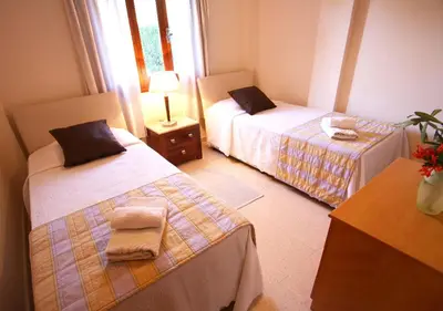 a bedroom with two beds and a table with a lamp at Maria Villa in Pissouri