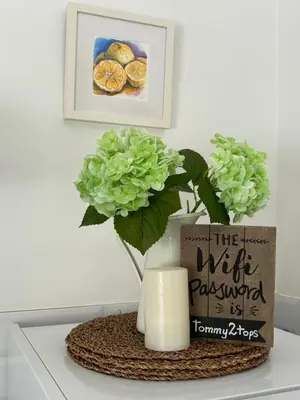 a vase with a plant and a candle on a table at Bay Cottage Beautiful cosy luxury cottage - Beach area in Pissouri