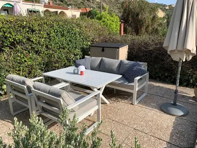 a table and chairs and an umbrella on a patio at Bay Cottage Beautiful cosy luxury cottage - Beach area in Pissouri