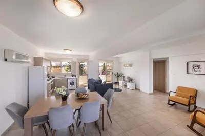 a dining room and living room with a table and chairs at Pelagos apartment 6 in Paralimni