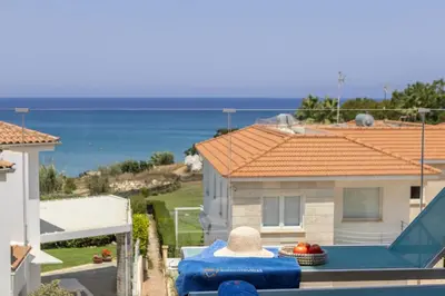 a view of a house with a pool and the ocean at Pelagos apartment 6 in Paralimni