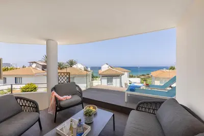 a living room with a balcony with a swimming pool at Pelagos apartment 6 in Paralimni