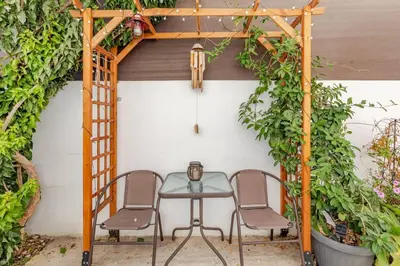 a table and chairs under a pergola with plants at Cozy and Traditional - EC Studios in Larnaka