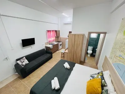 a living room with a black couch and a tv at Cozy and Traditional - EC Studios in Larnaka