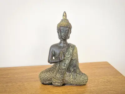 a bronze statue sitting on a wooden table at Villa Green garden in Ayia Napa