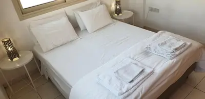 a white bed with two towels on top of it at ELLA LUXURY APARTMENT - (BREAKBOOKING CY) in Limassol