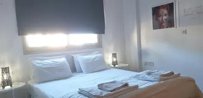 a white bedroom with a bed with towels on it at ELLA LUXURY APARTMENT - (BREAKBOOKING CY) in Limassol