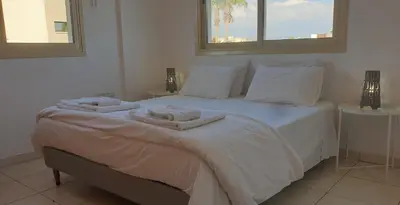 a bedroom with a white bed with towels on it at ELLA LUXURY APARTMENT - (BREAKBOOKING CY) in Limassol