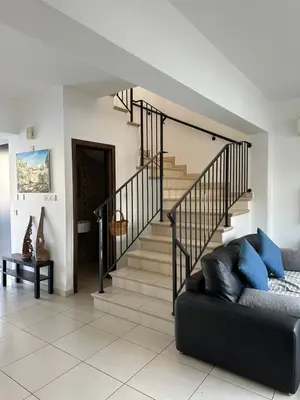 a living room with a staircase and a couch at LC Palm Villa in Protaras