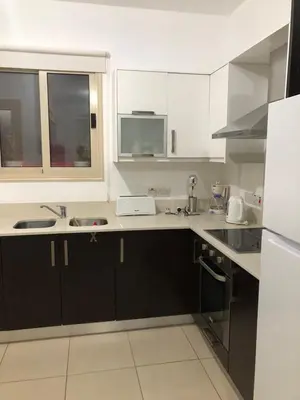 a kitchen with white cabinets and a sink at LC Palm Villa in Protaras