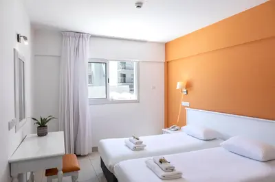 a hotel room with two beds and a window at Mia Hotel Apartment in Ayia Napa