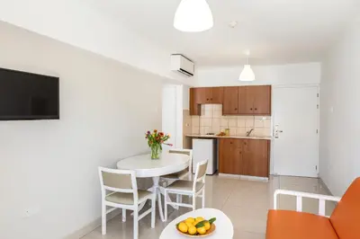 a kitchen and living room with a table and chairs at Mia Hotel Apartment in Ayia Napa