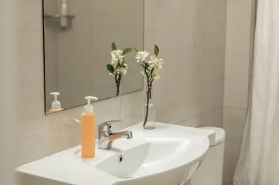 a bathroom sink with a vase of flowers on it at Mia Hotel Apartment in Ayia Napa