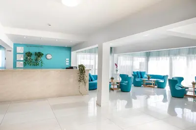 an office lobby with blue chairs and a counter at Mia Hotel Apartment in Ayia Napa