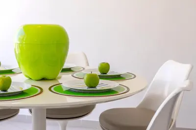 a table with plates and a green bowl on top at Protaras Pallini 201 Seaside Suite in Protaras