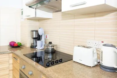 a kitchen with a stove top oven next to a microwave at GABRIELA - Coralli Beachfront Apartment in Protaras