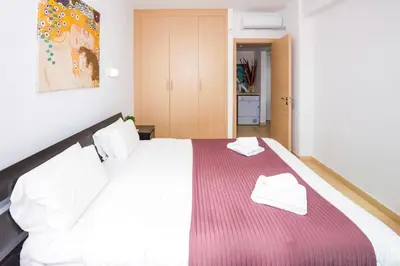 a bedroom with a large bed with two white towels on it at LAILA - Coralli Beachfront Apartment in Protaras