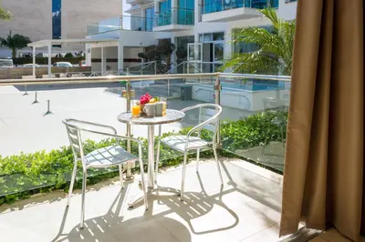 a table and chairs on the balcony of a building at ALICIA - Coralli Beachfront Apartment in Paralimni