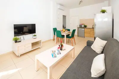 a living room with a couch and a table at ALICIA - Coralli Beachfront Apartment in Paralimni