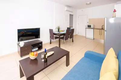 a living room with a couch and a table at BLISS - Coralli Beachfront Apartment in Protaras