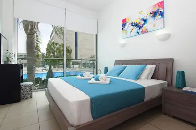 a bedroom with a bed with towels on it at DIANA - Coralli Beachfront Apartment in Protaras