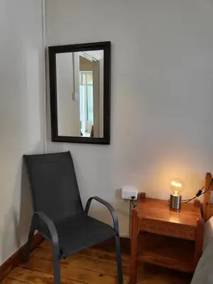 a black chair sitting next to a table with a mirror at ThePlatres.Nest in Platres