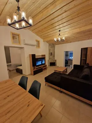 a living room with a couch and a table at Aprosmeno Jacuzzi House 4 in Agros
