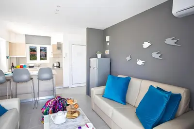 a living room with a white couch and blue pillows at Evas Apartment in Protaras