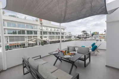 a living room with a table and chairs on a balcony at Evas Apartment in Protaras