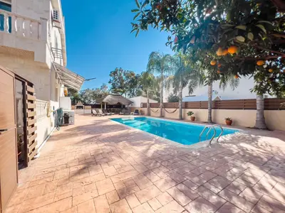 a swimming pool with an orange tree next to a building at FAME villa with Private Pool and Gazebo in Ayia Napa