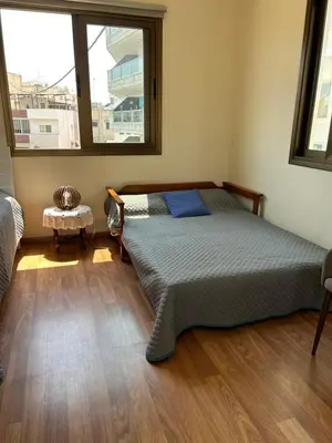 a bedroom with a bed and a large window at Extremely comfy apt with spacious private terrace 10min walk to the beach & in Town in Larnaka