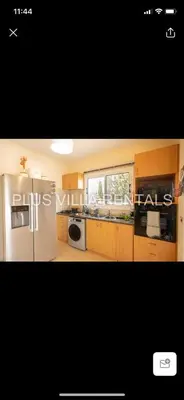 a kitchen with a white refrigerator and a window at Villa 4 in Ayia Thekla in Ayia Napa