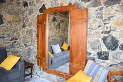 a mirror with a couch in a stone wall at Konatzin tou Massou by Raise in Moutoullas